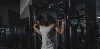 Mężczyzna w stroju sportowym podnosi ciężary na siłowni