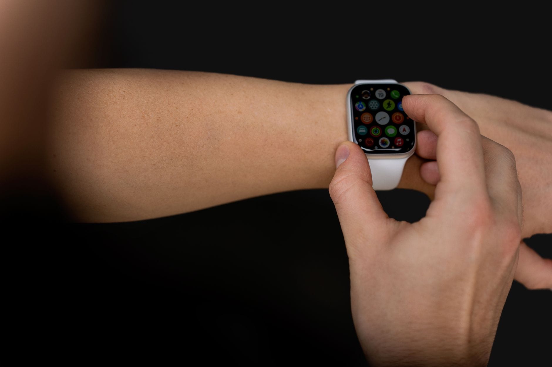 Osoba obsługuje dotykowy smartwatch na tle czerni