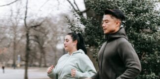 Czy trening na czczo naprawdę spala więcej tłuszczu, czy to tylko popularny mit Biegająca kobieta z nadwagą i azjatycki trener w miejskim parku
