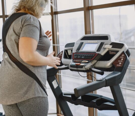 Kobieta ćwicząca na bieżni w siłowni podczas treningu cardio