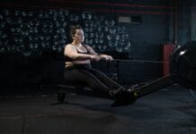 Kobieta plus size ćwicząca na wioślarzu w domu