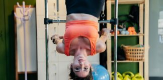 Kobieta wykonująca odwrócone ćwiczenie Pilates na reformerze w siłowni